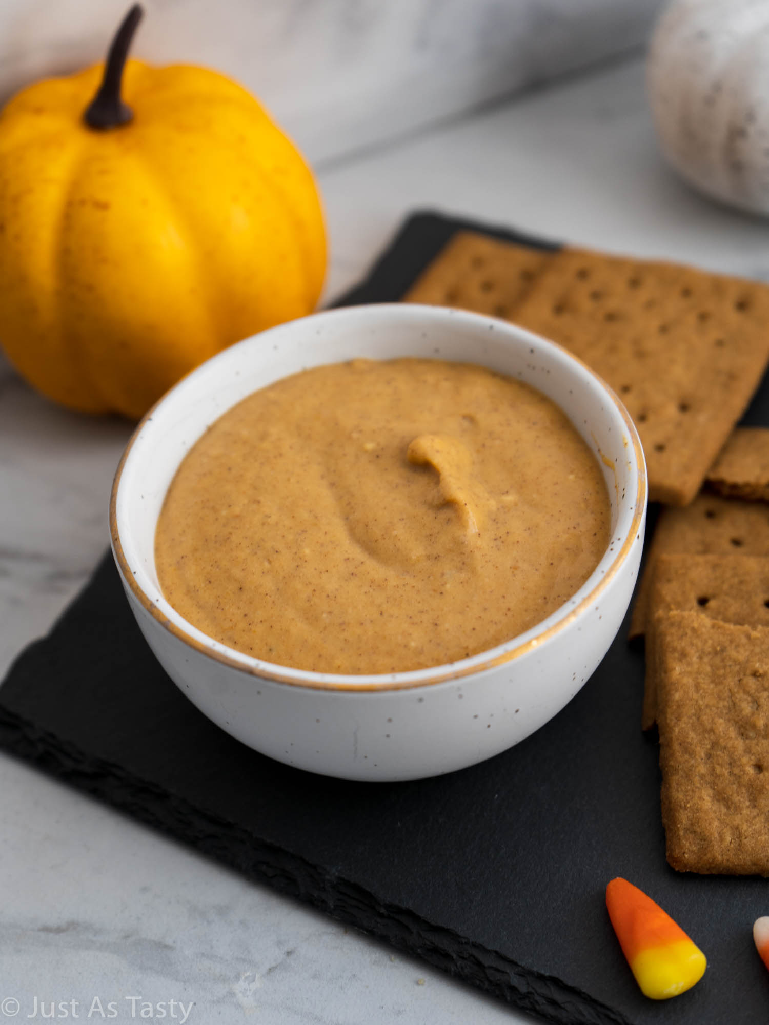 Pumpkin cream cheese dip in a white bowl. 