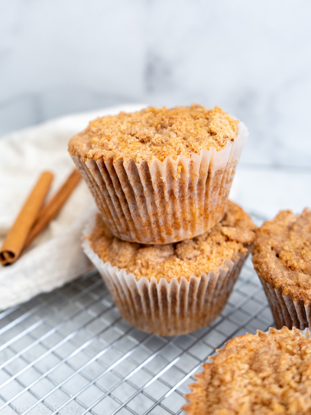 Two cinnamon streusel muffins stacked on top of each other.