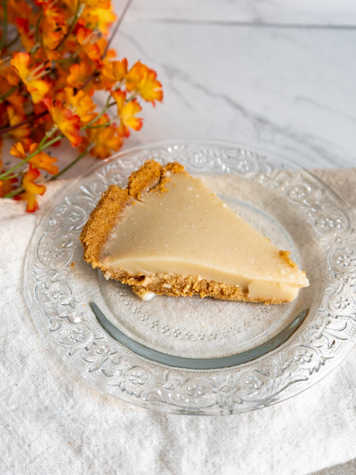 Slice of salted honey pie on a glass plate.