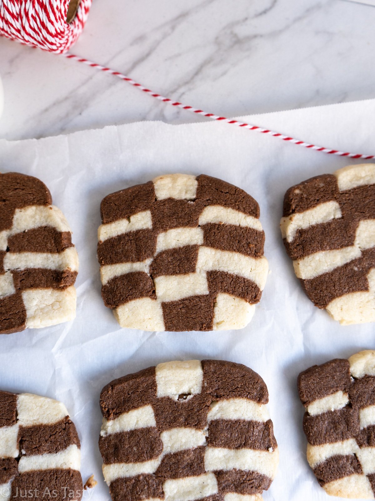 Checkerboard cookies on white parchment paper.