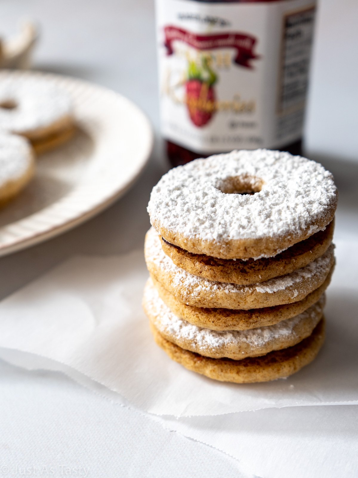 Stack of sandwich cookies dusted with powdered sugar.