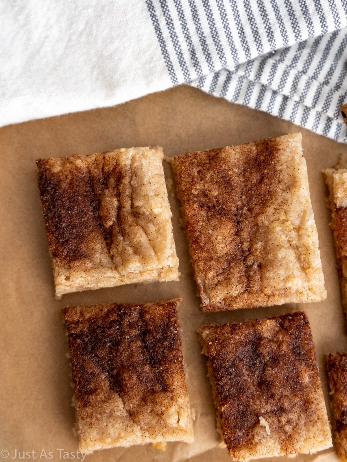 Snickerdoodle bars lined up on brown parchment paper.