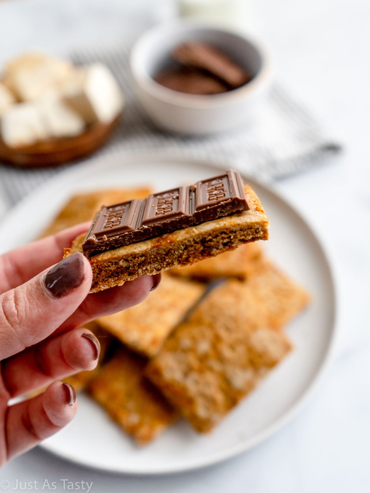 Close-up of a graham cracker topped with a piece of milk chocolate.