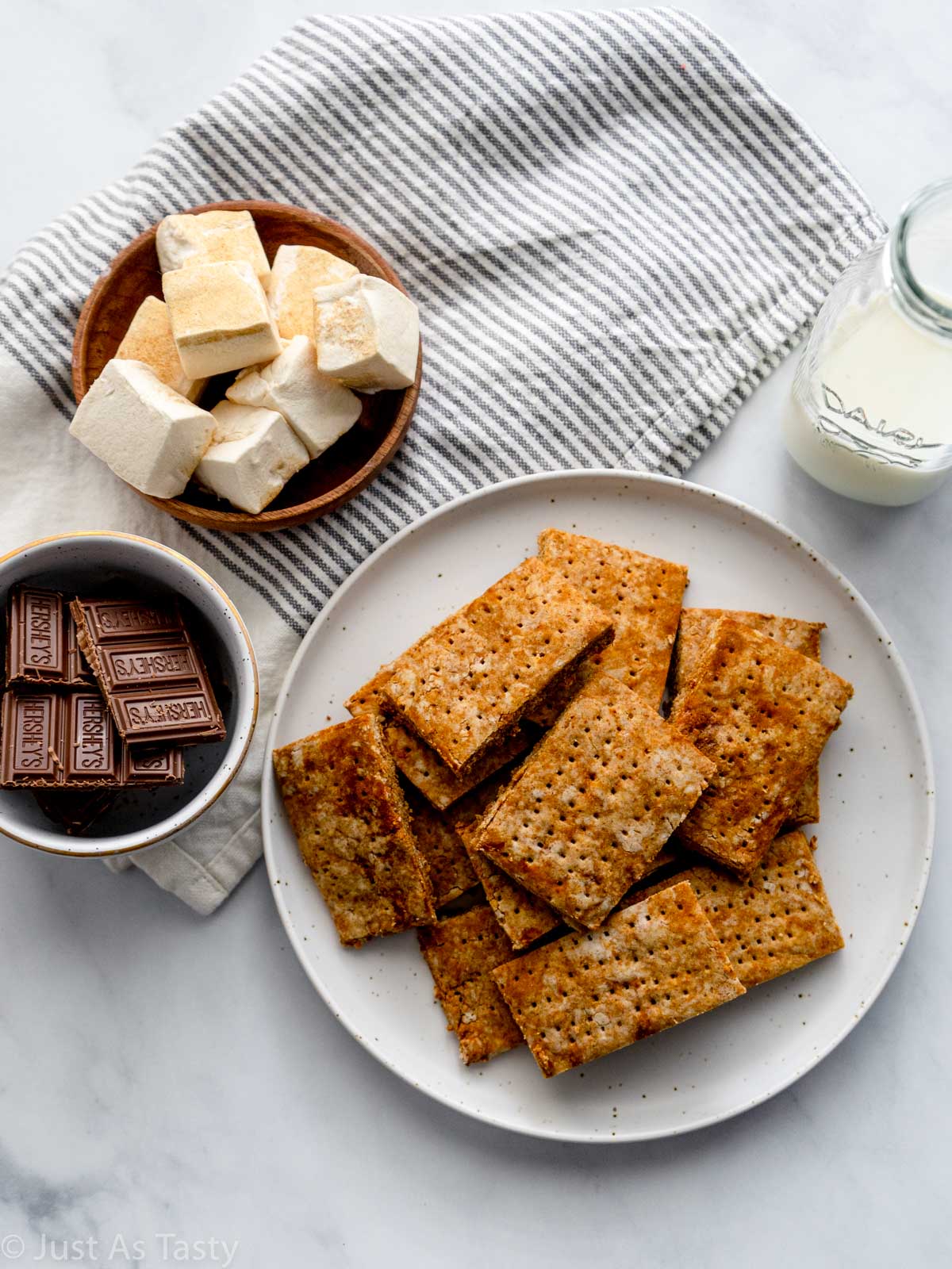 Gluten free graham crackers piled onto a white plate. 