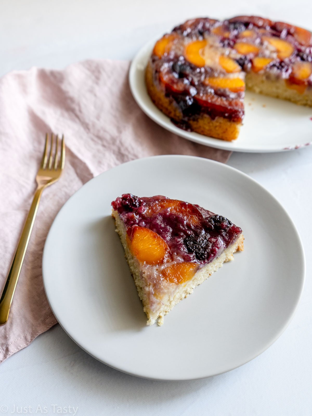Slice of peach upside down cake on a plate.