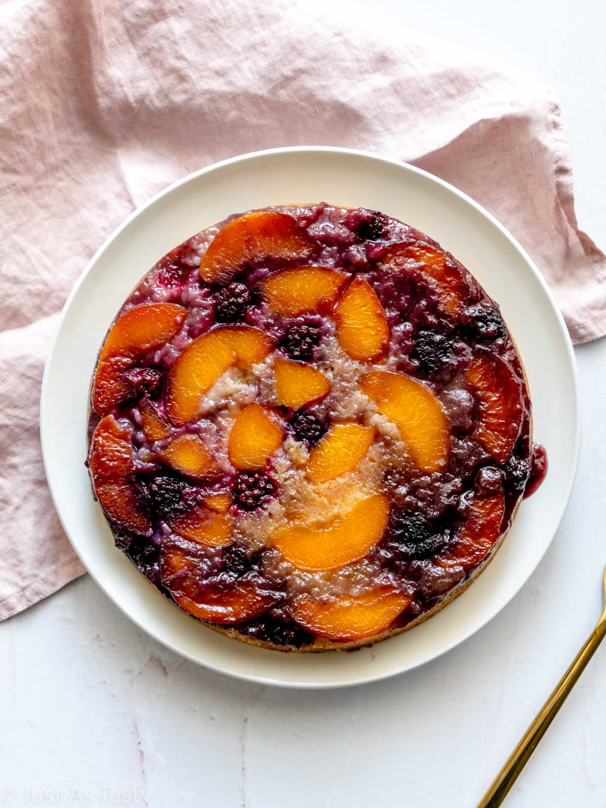 Peach upside down cake topped with blackberries and peach slices.