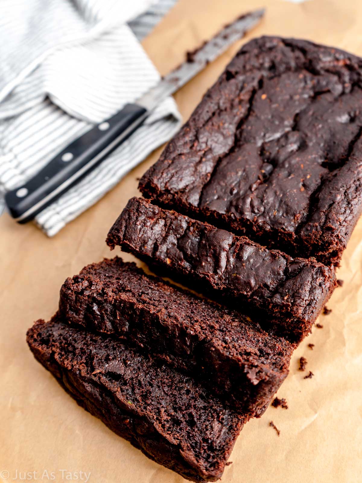 Sliced chocolate zucchini bread on parchment paper.