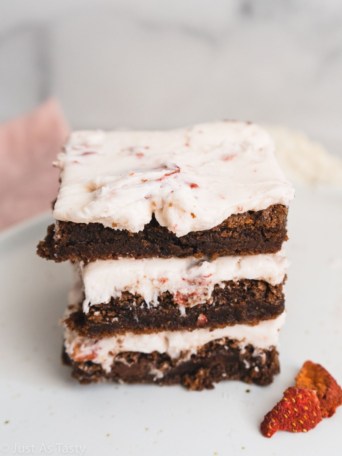Stack of frosted strawberry brownies.
