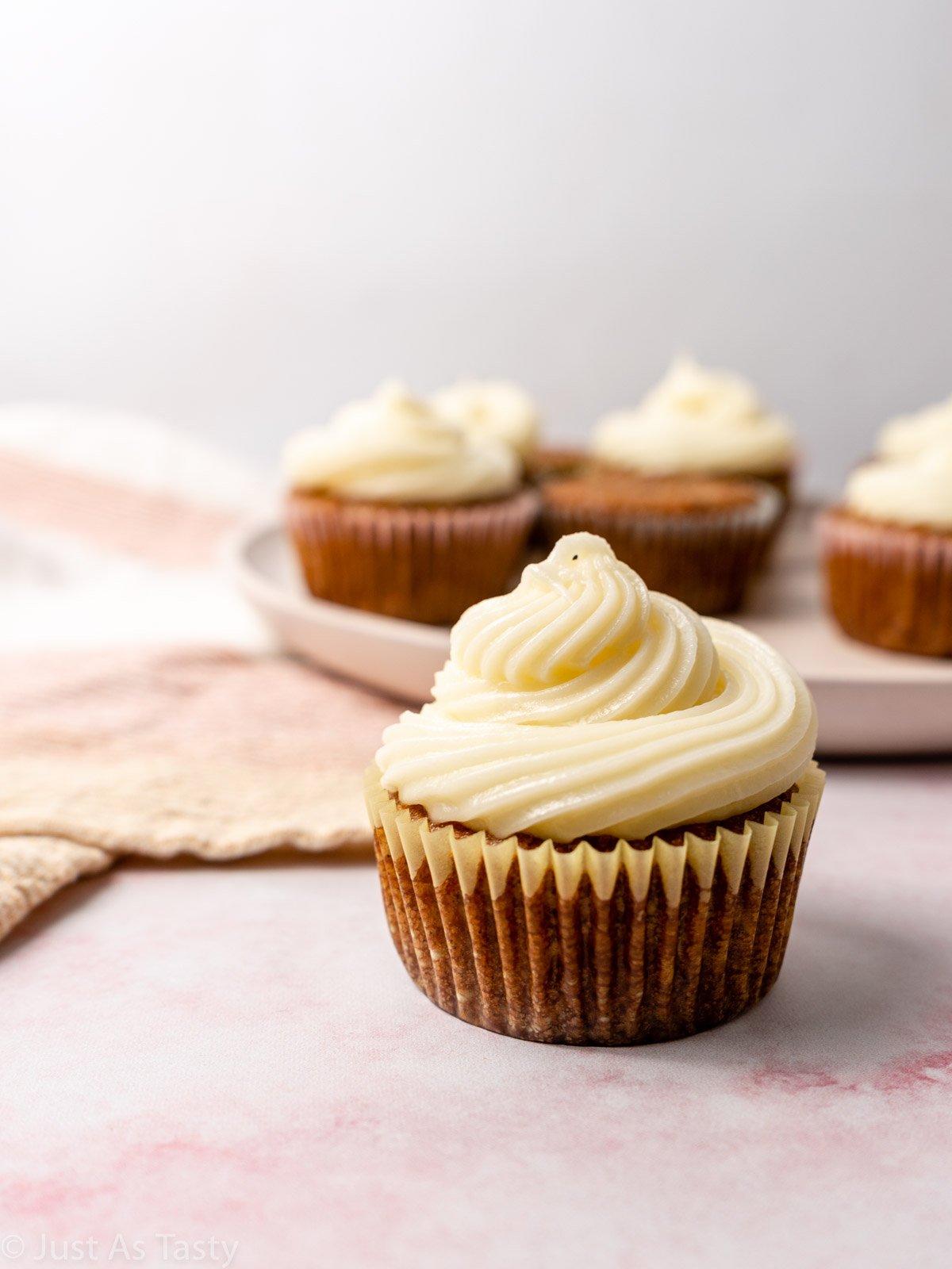 Gluten free carrot cake cupcake topped with cream cheese frosting.