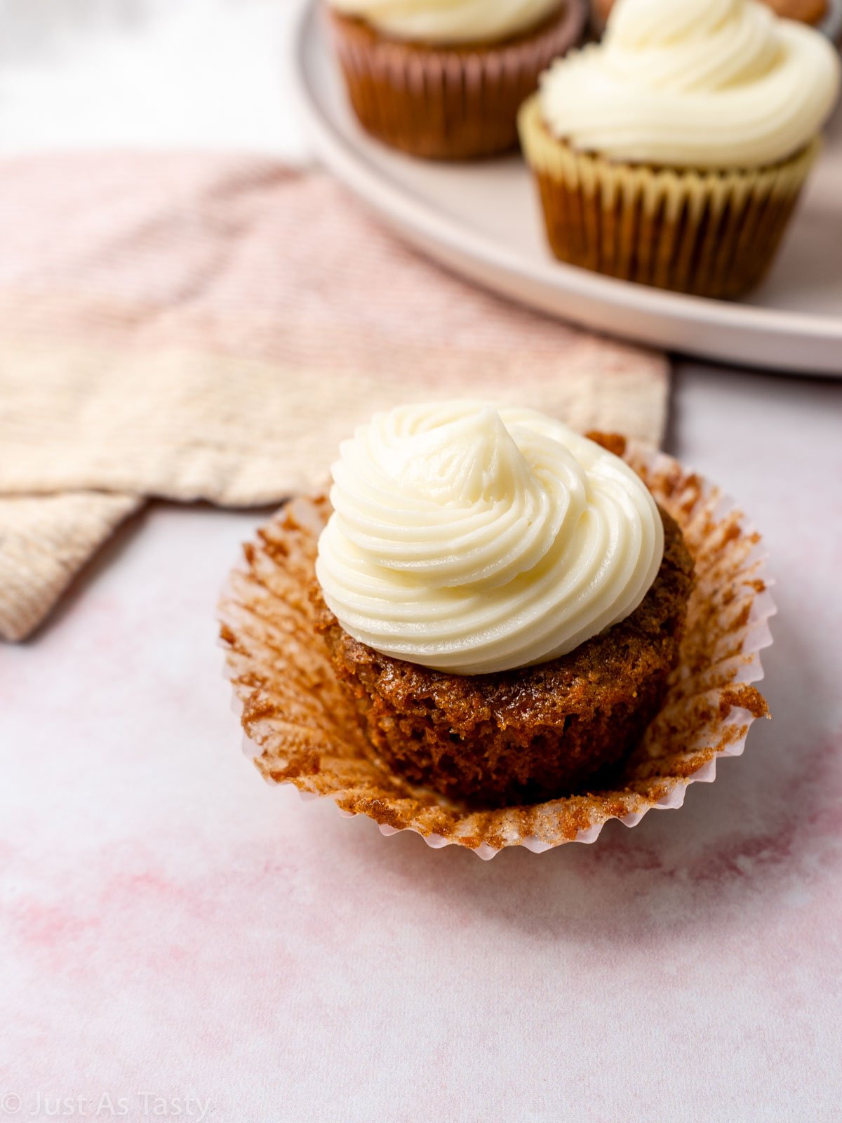 Close-up of a frosted gluten free carrot cake cupcake.