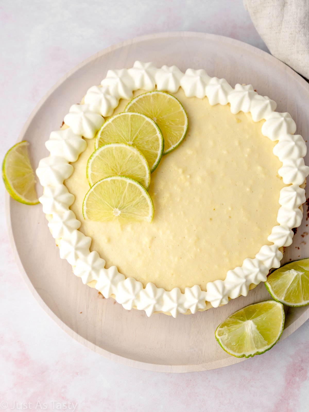Key lime pie topped with whipped cream and lime slices.