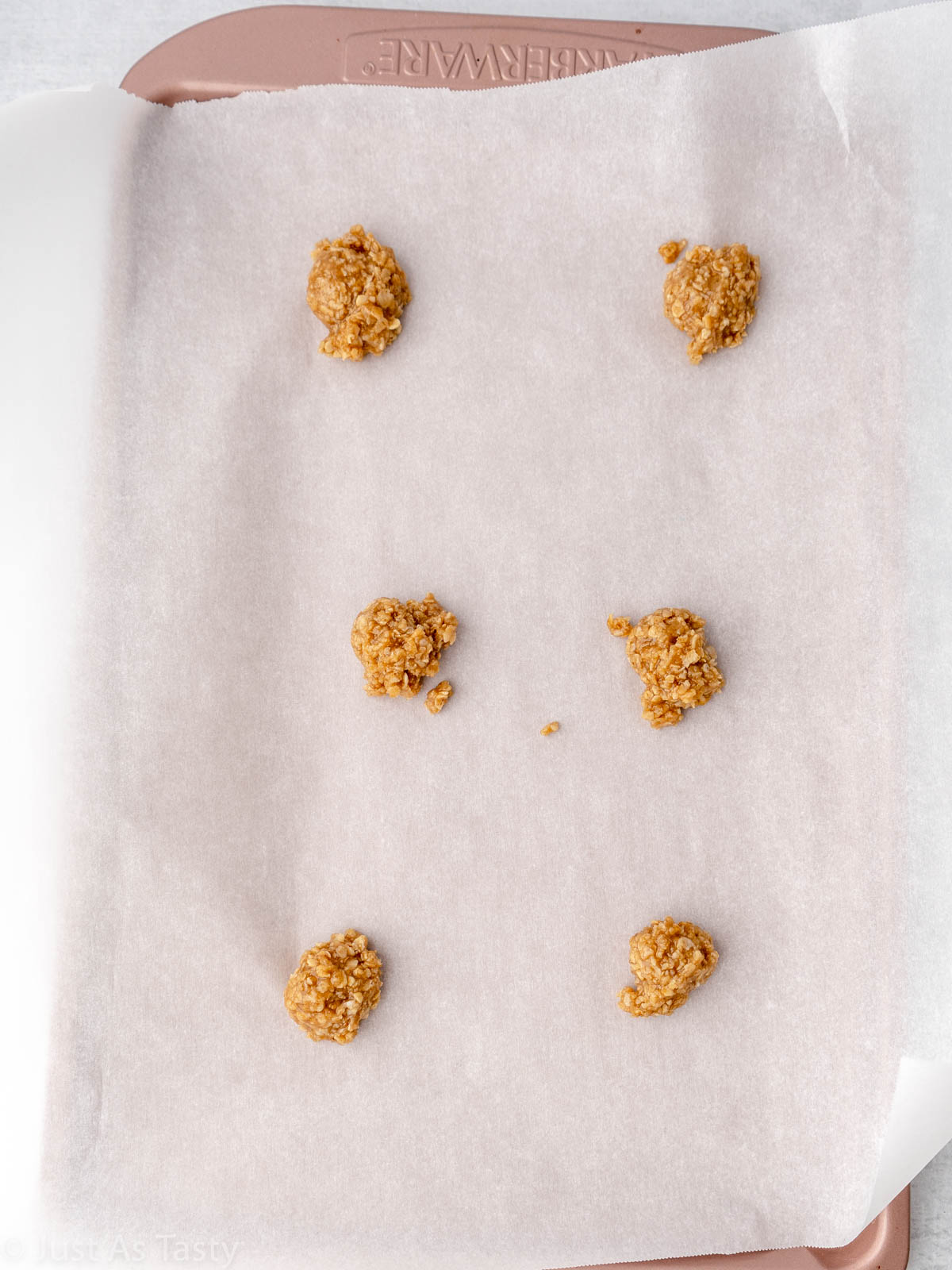 Teaspoons of cookie dough on a lined baking sheet.