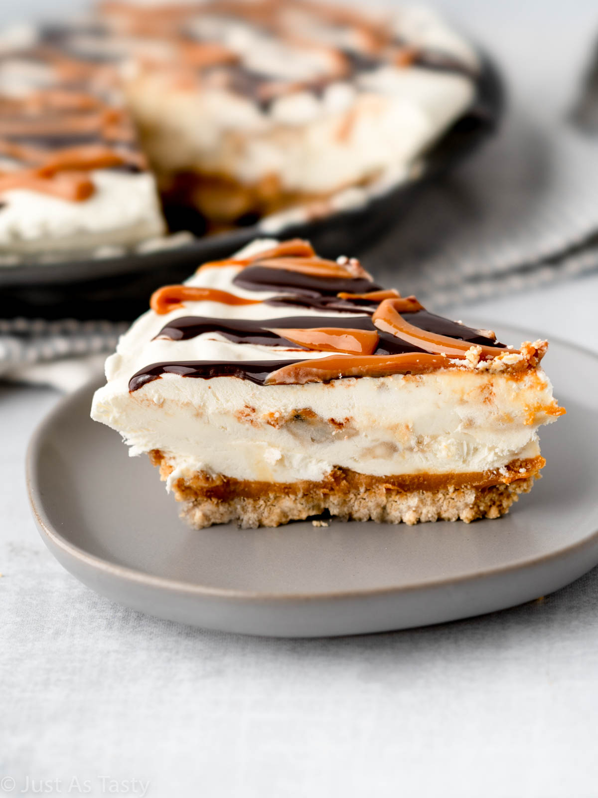 Slice of caramel banana pie on a grey plate. 