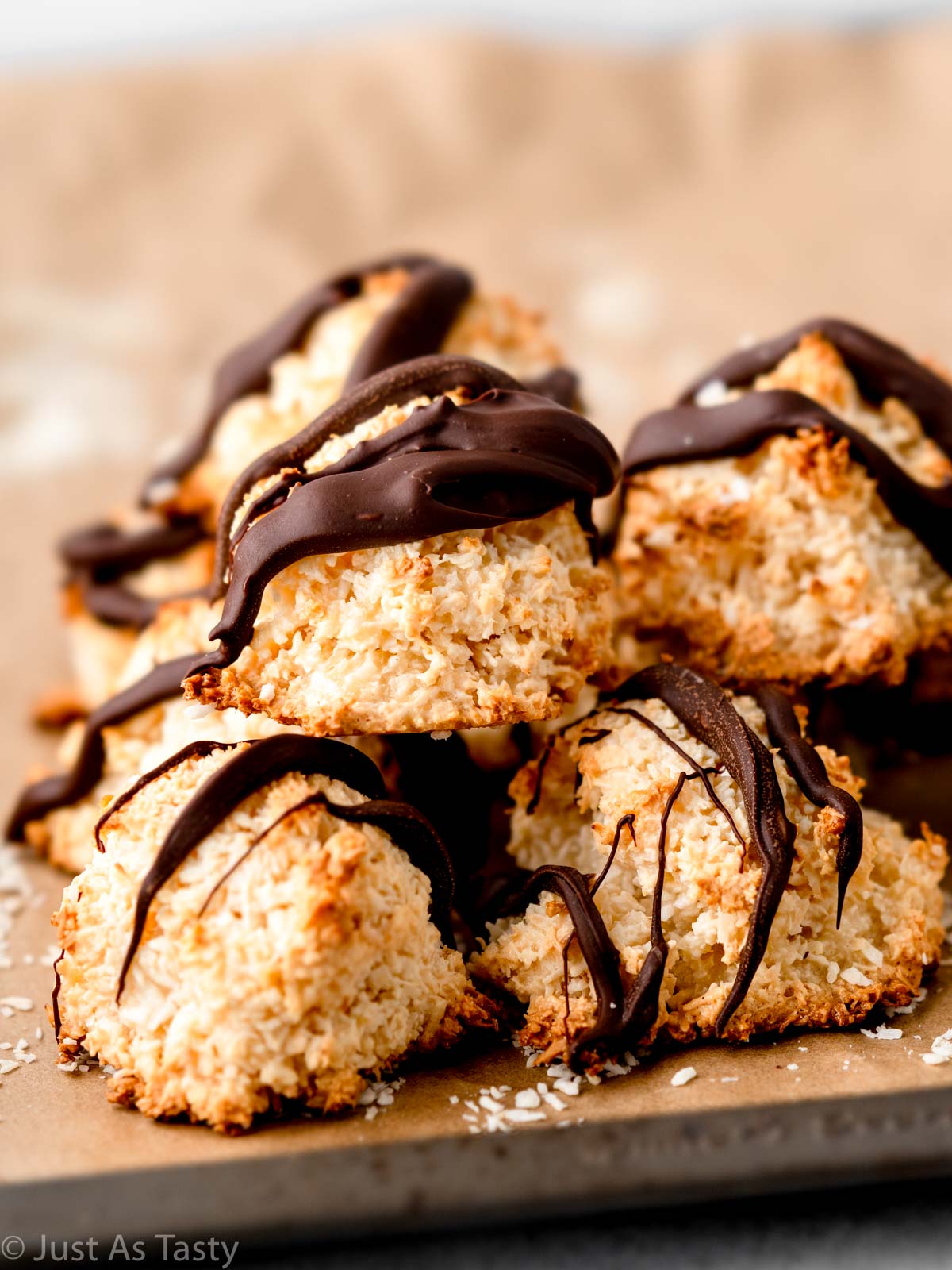 Stack of coconut macaroons drizzled with chocolate.