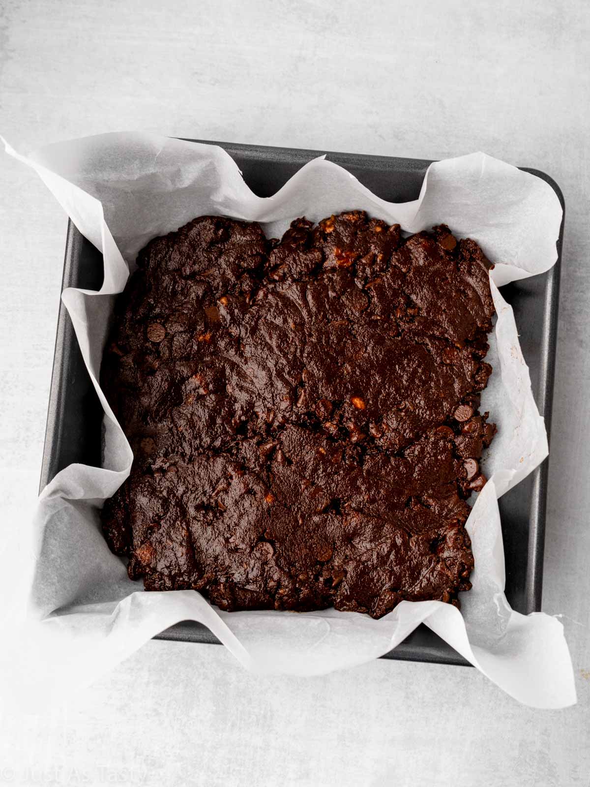 Brownie batter in a square pan.