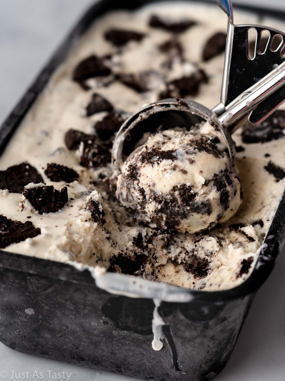 Close-up of Oreo ice cream being scooped out of container.