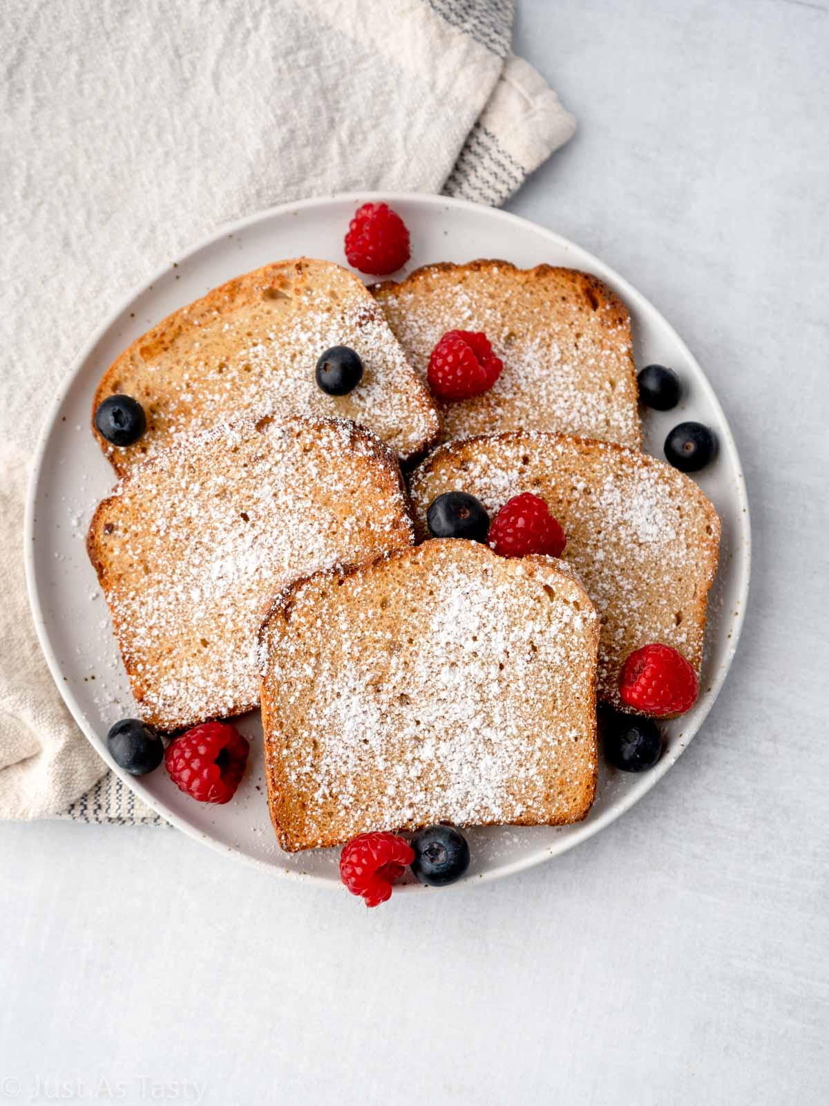 Air fryer French toast on a plate with mixed berries.