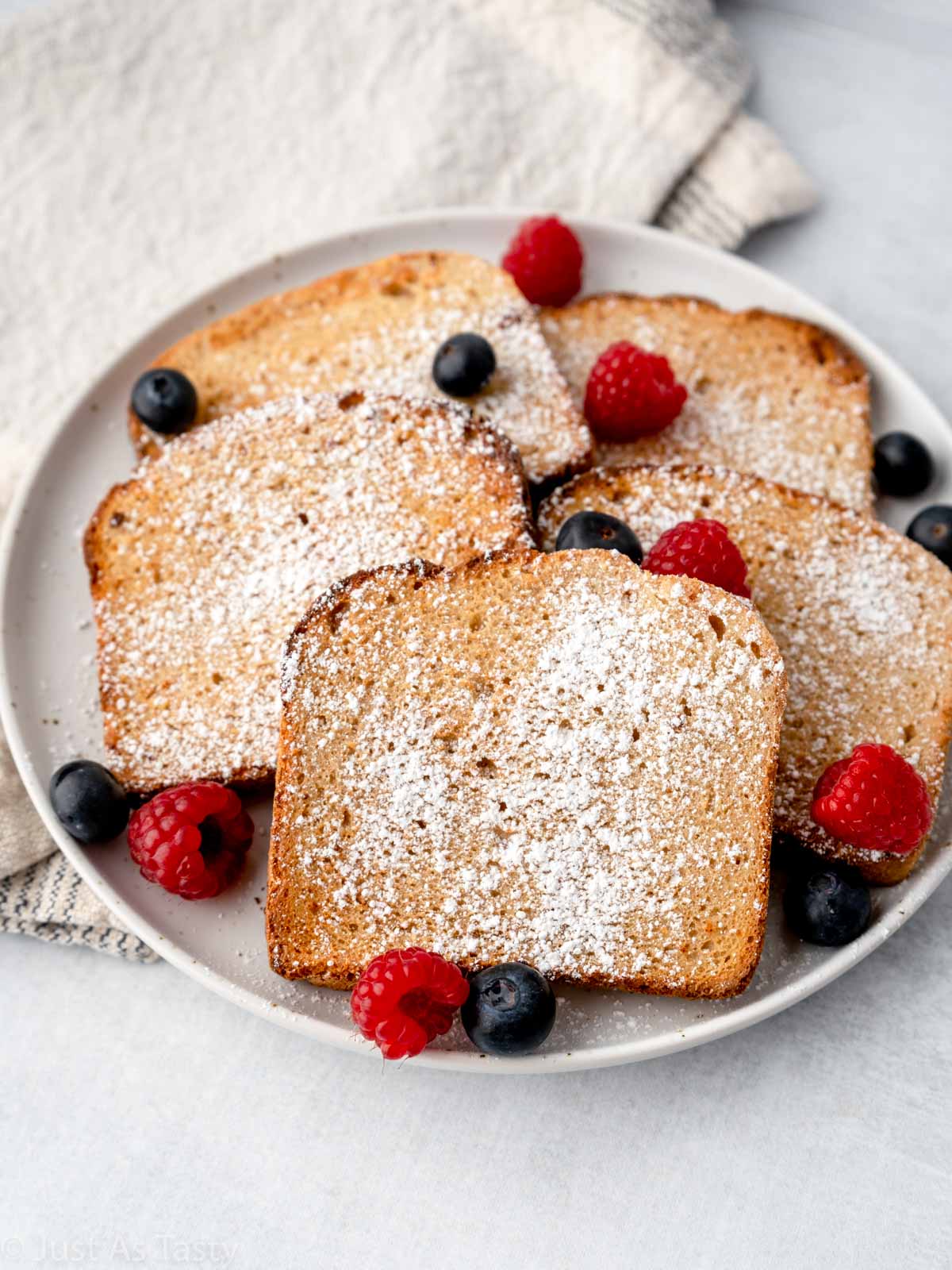 Air fryer French toast on a plate with mixed berries.