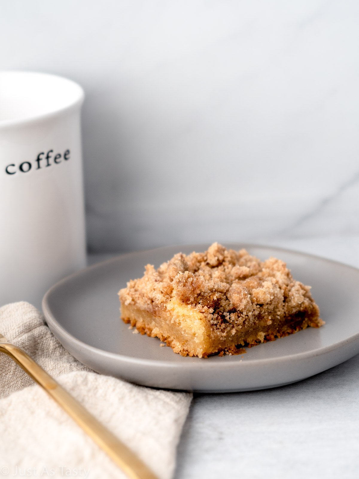 Close-up of a slice of coffee cake on a grey plate. 