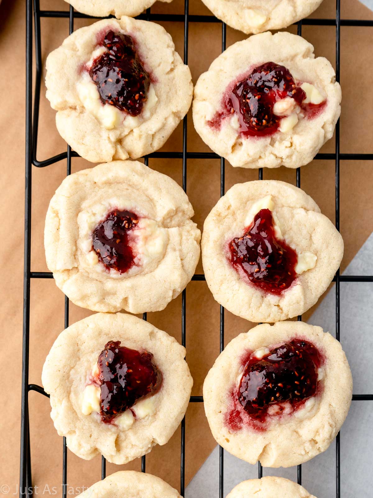 Raspberry thumbprint cookies on a wire cooling rack.