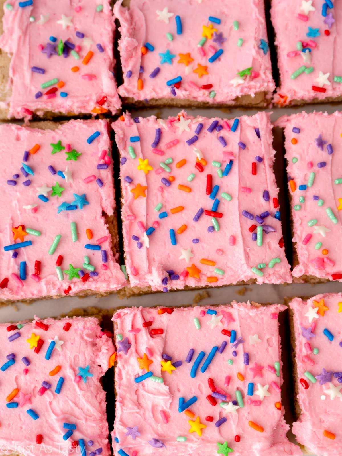 Close-up of pink frosted sugar cookie cake bars.