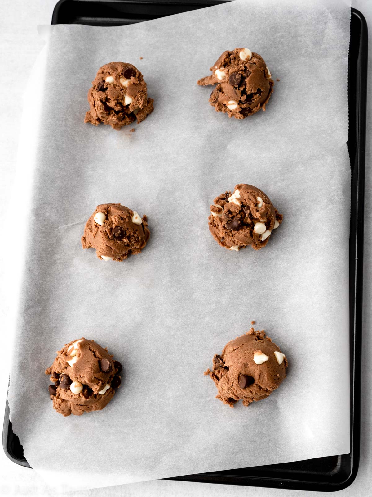 Scoops of cookie dough on a baking sheet.