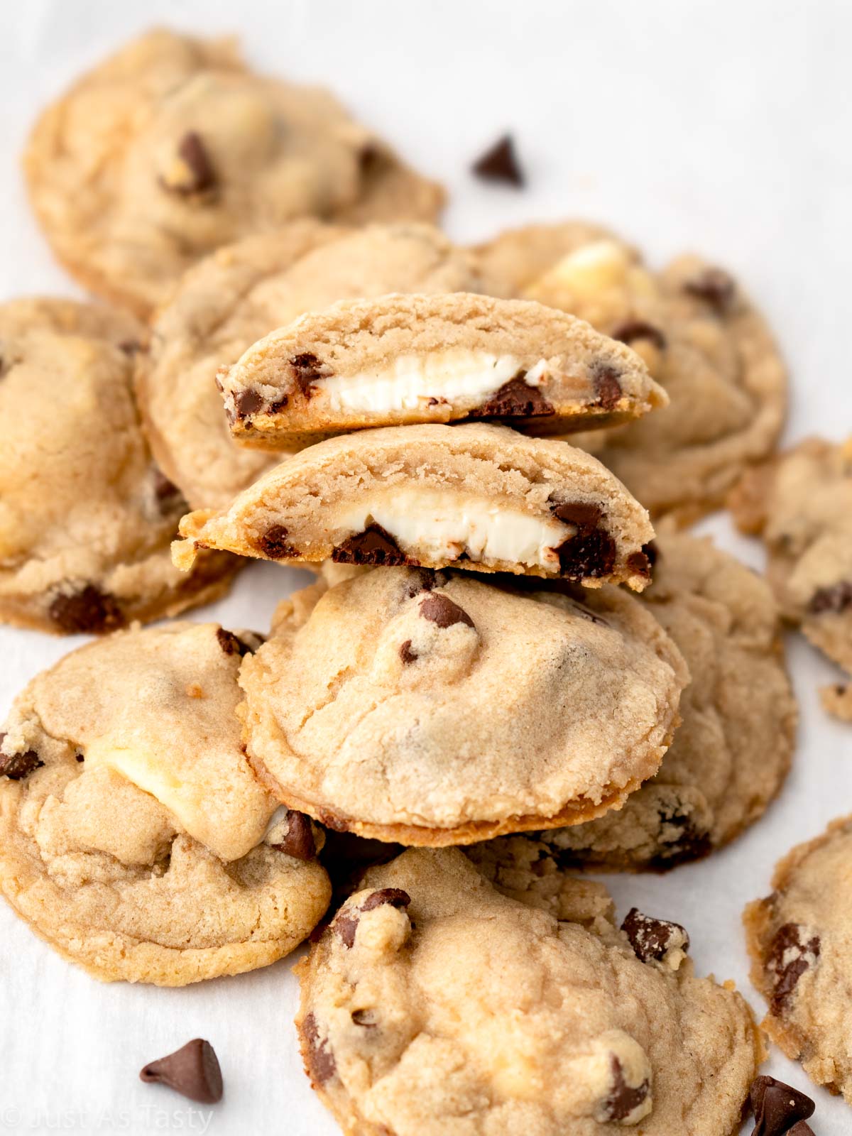 Pile of cheesecake stuffed cookies on white parchment paper. 