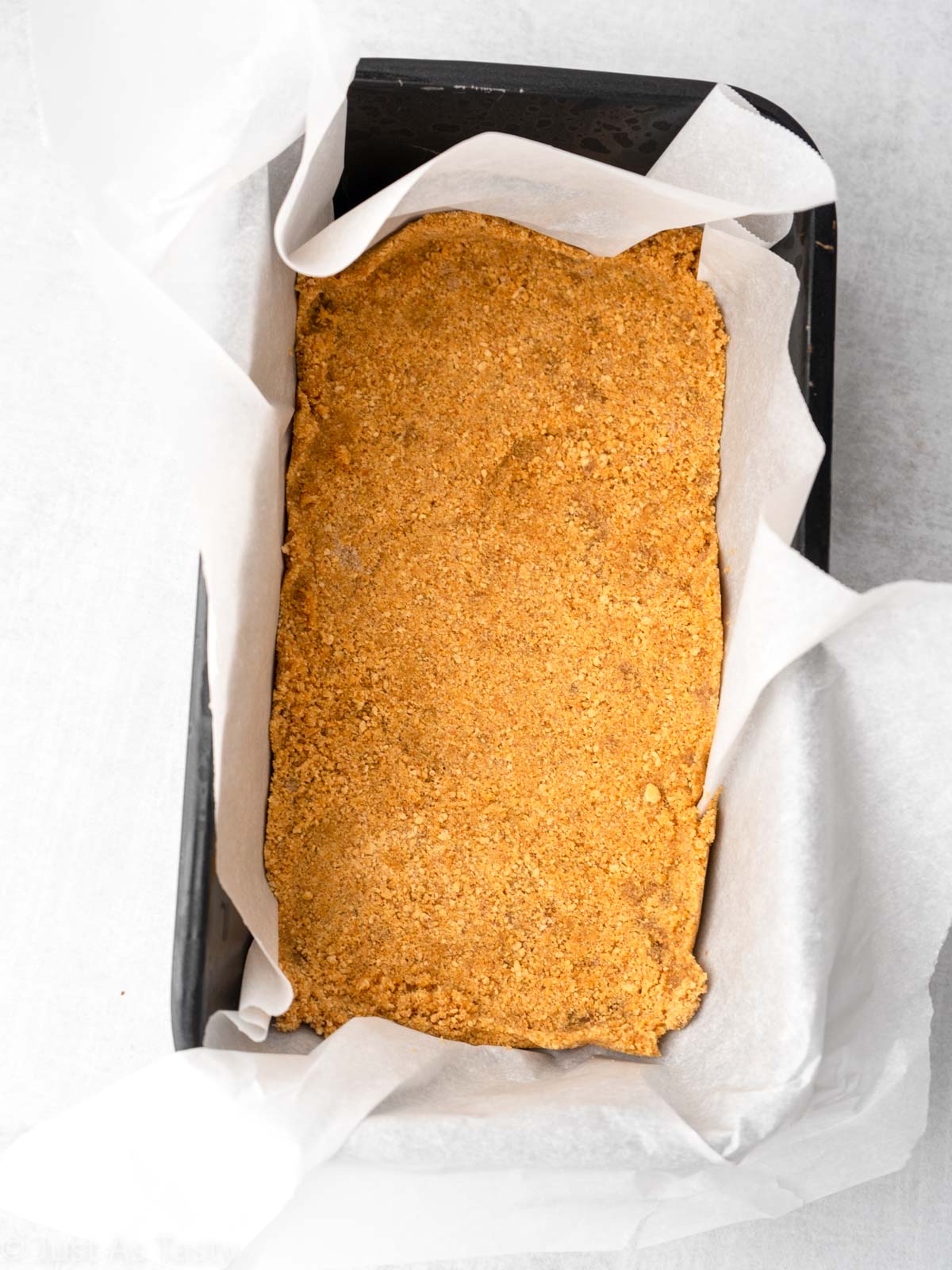 Graham cracker crust in a loaf pan. 