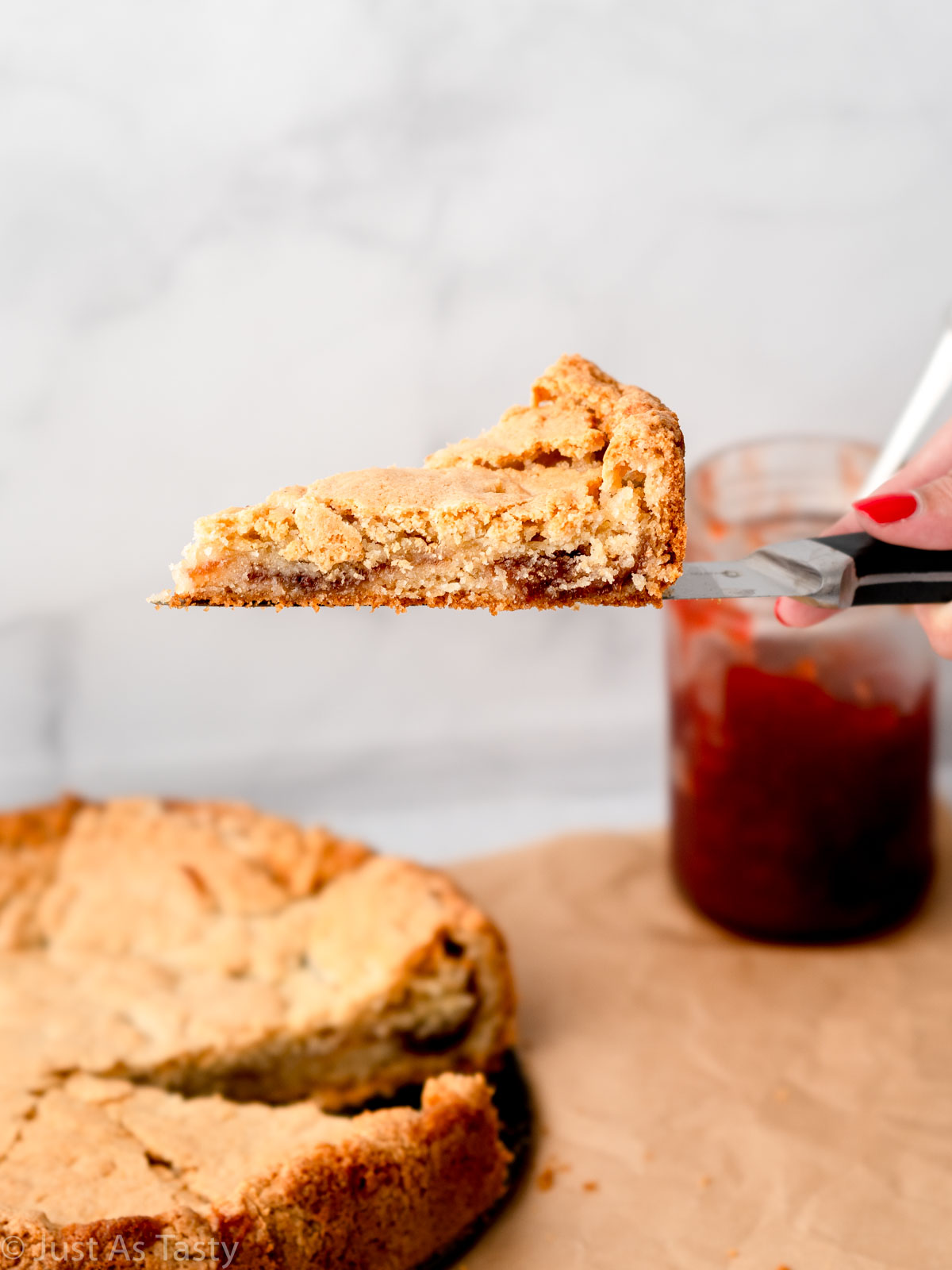 Slice of strawberry jam cake being pulled out.