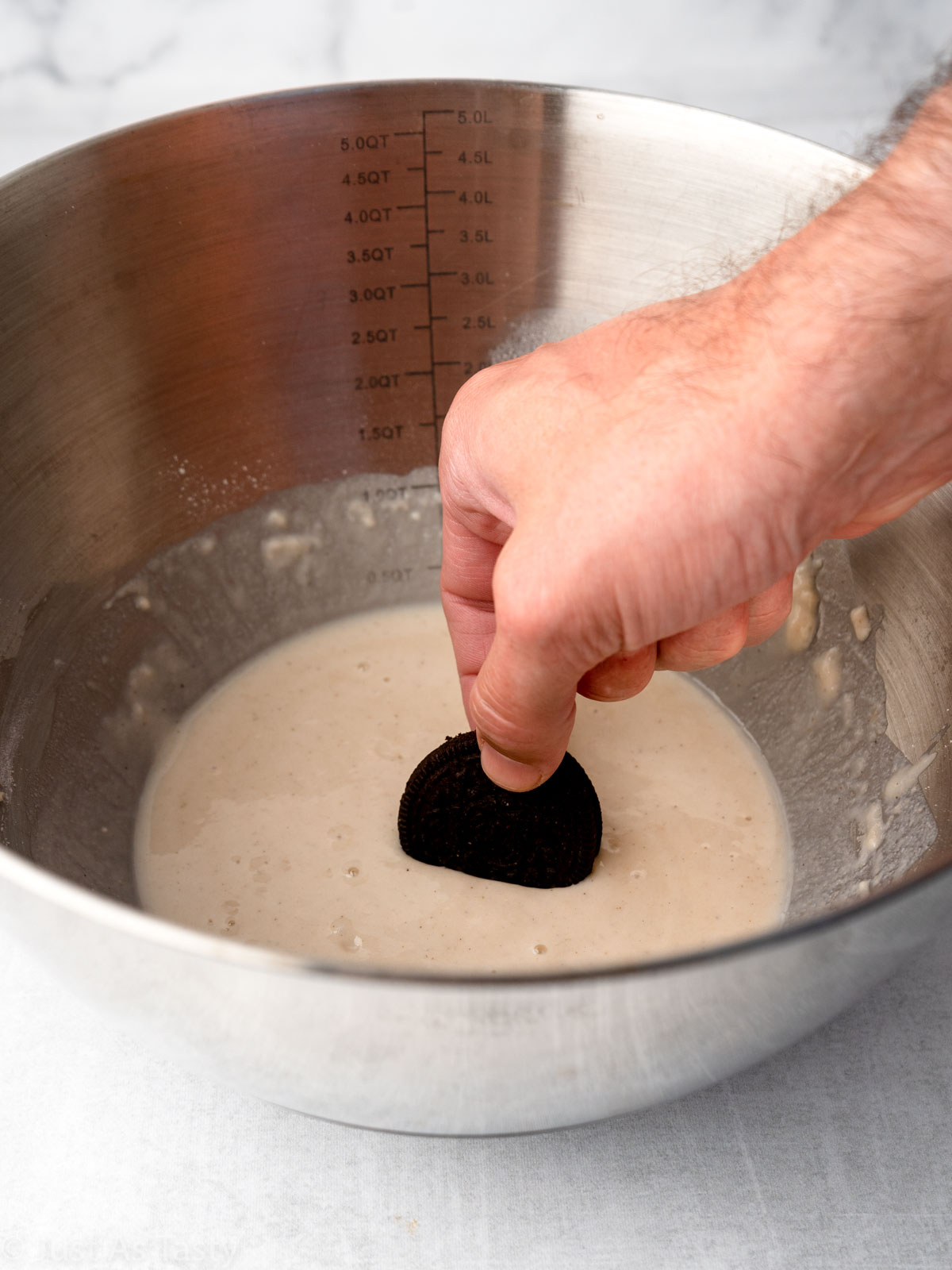 Oreo being dipped into batter.