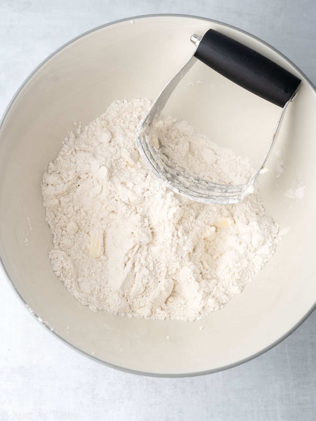 Dry ingredients in a bowl with a pastry blender. 