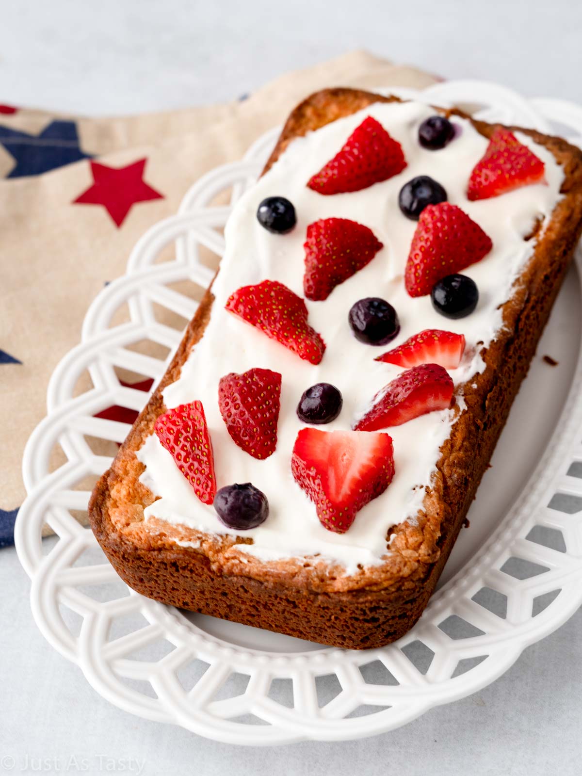 Gluten free pound cake topped with whipped cream and berries.