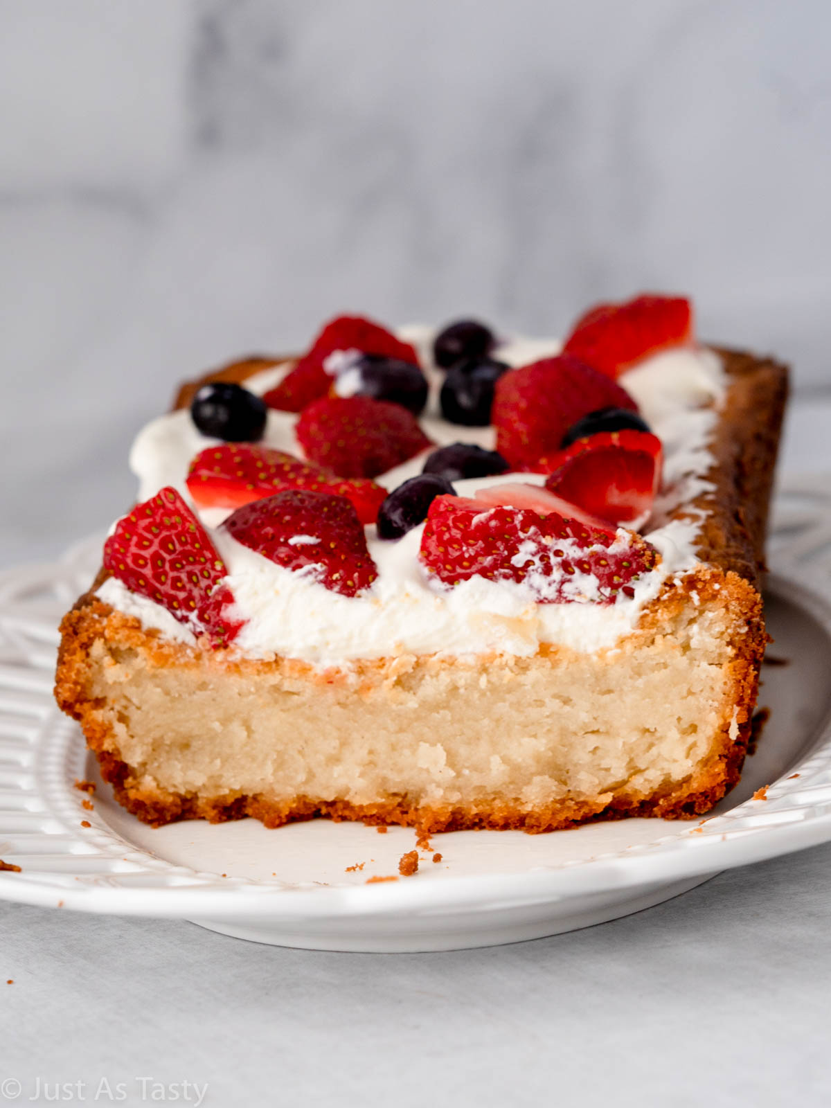 Sliced pound cake topped with whipped cream and berries. 