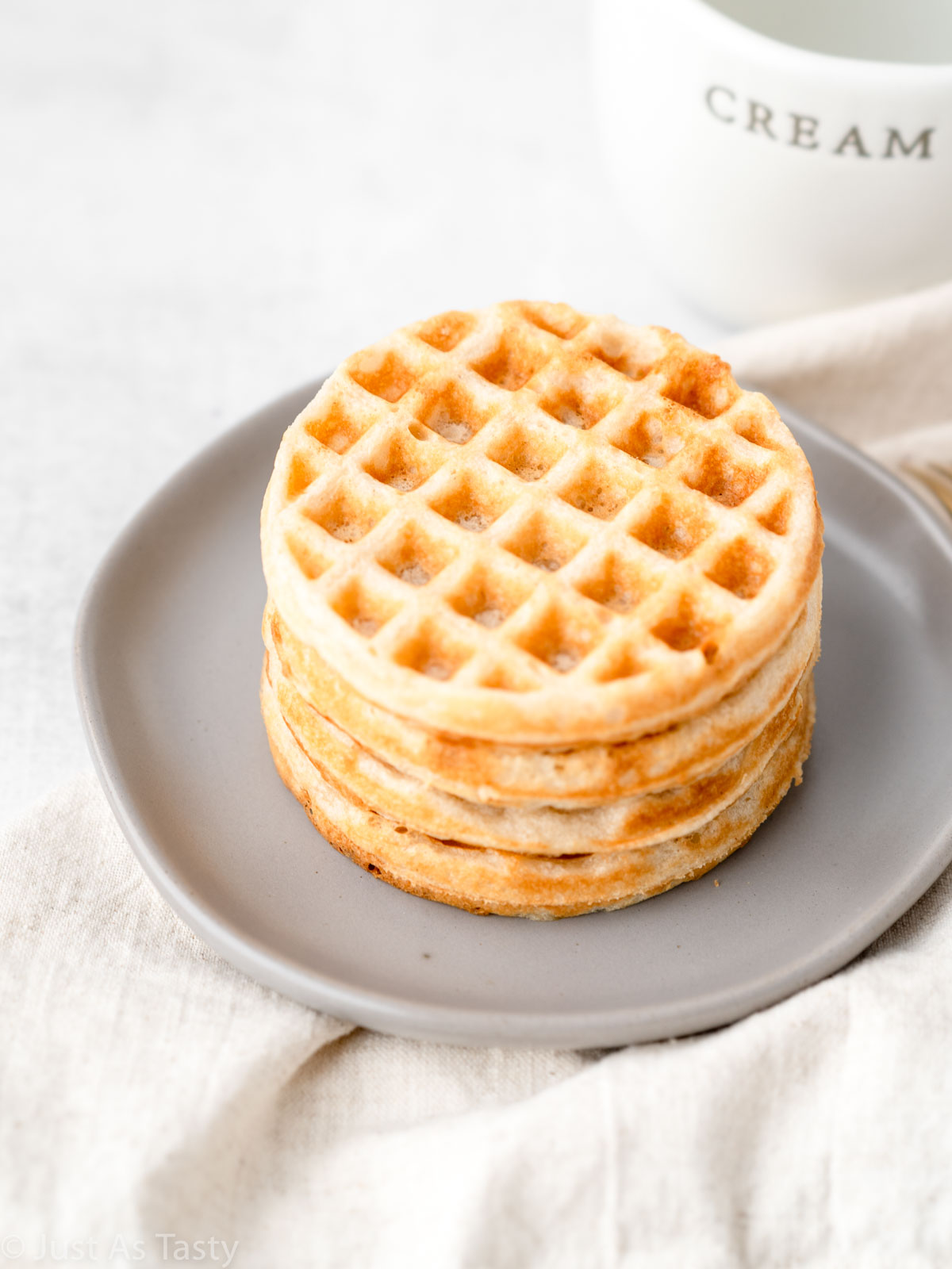 Gluten free waffles stacked on a plate.