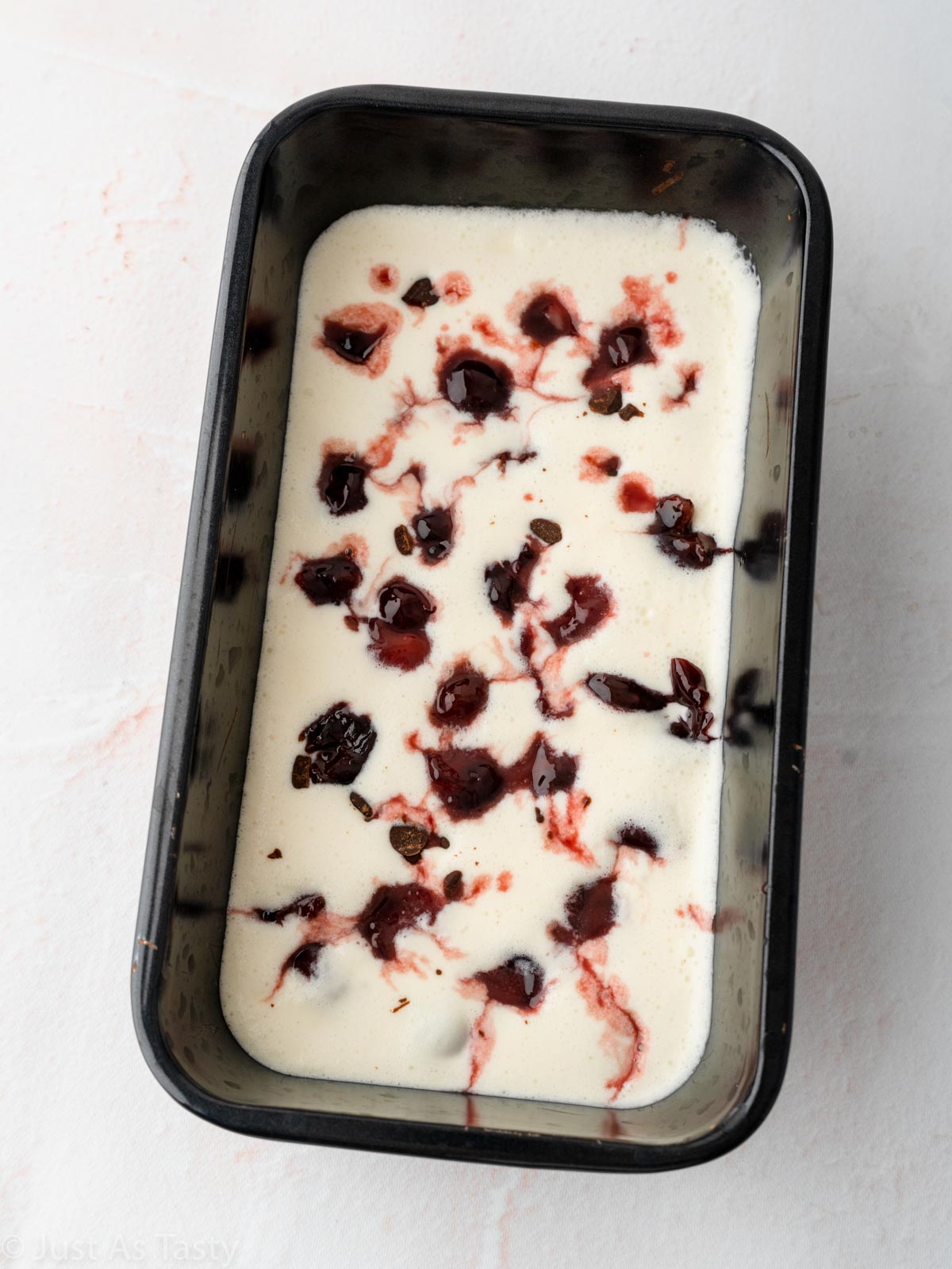 Black forest ice cream in loaf pan before freezing.