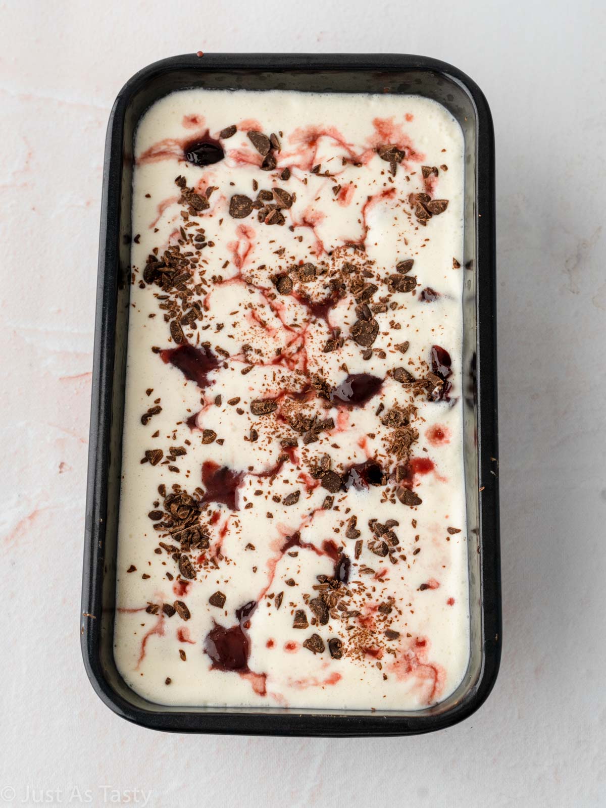 Black forest ice cream in loaf pan before freezing.