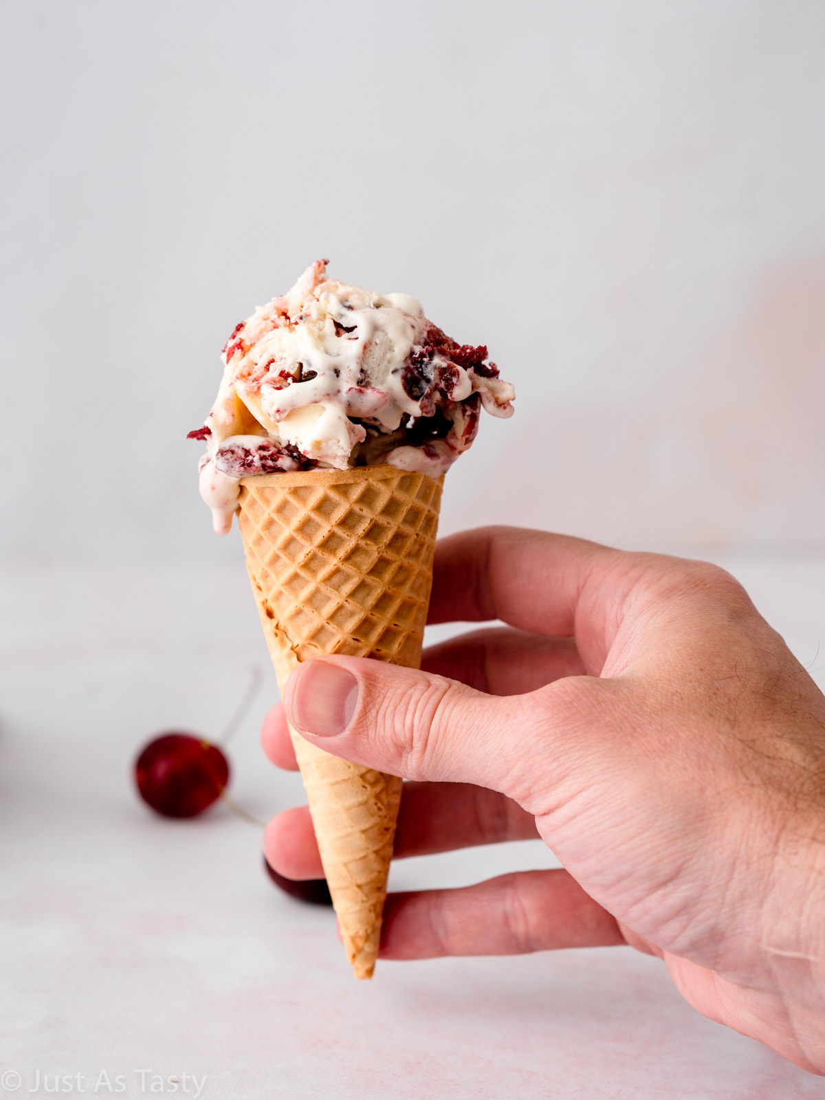 Black forest ice cream in a sugar cone.