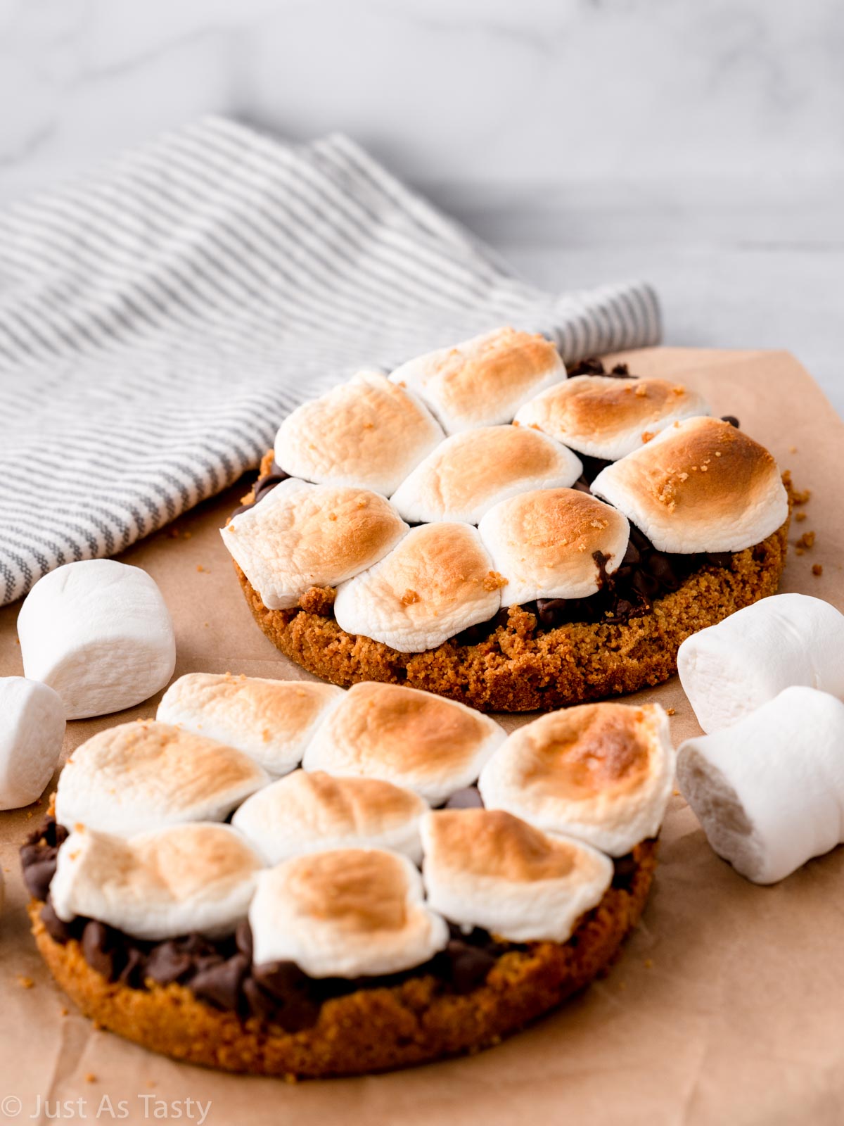 Two mini s'mores pies topped with toasted marshmallows.