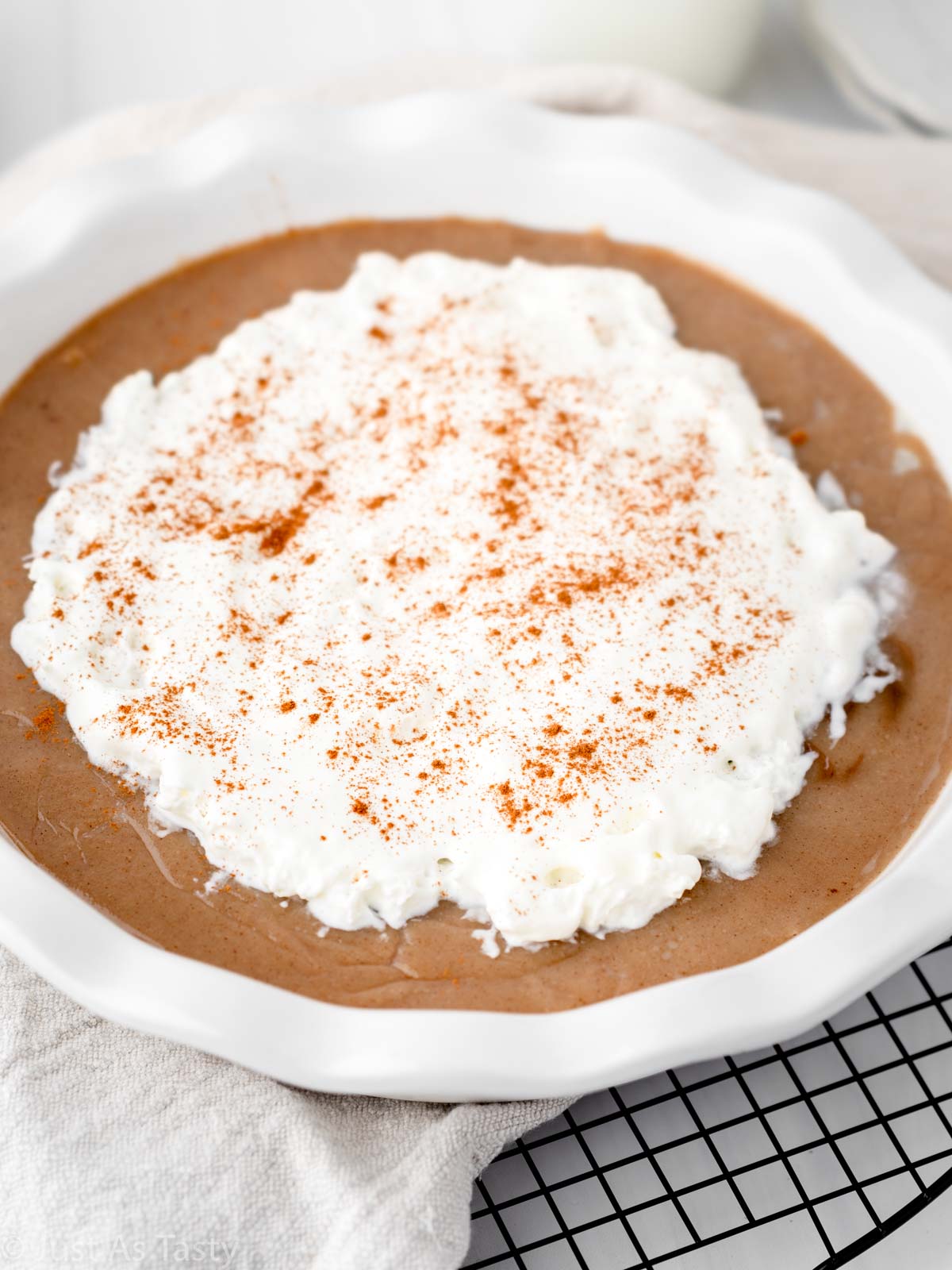 Close-up of butterscotch pie topped with whipped cream.