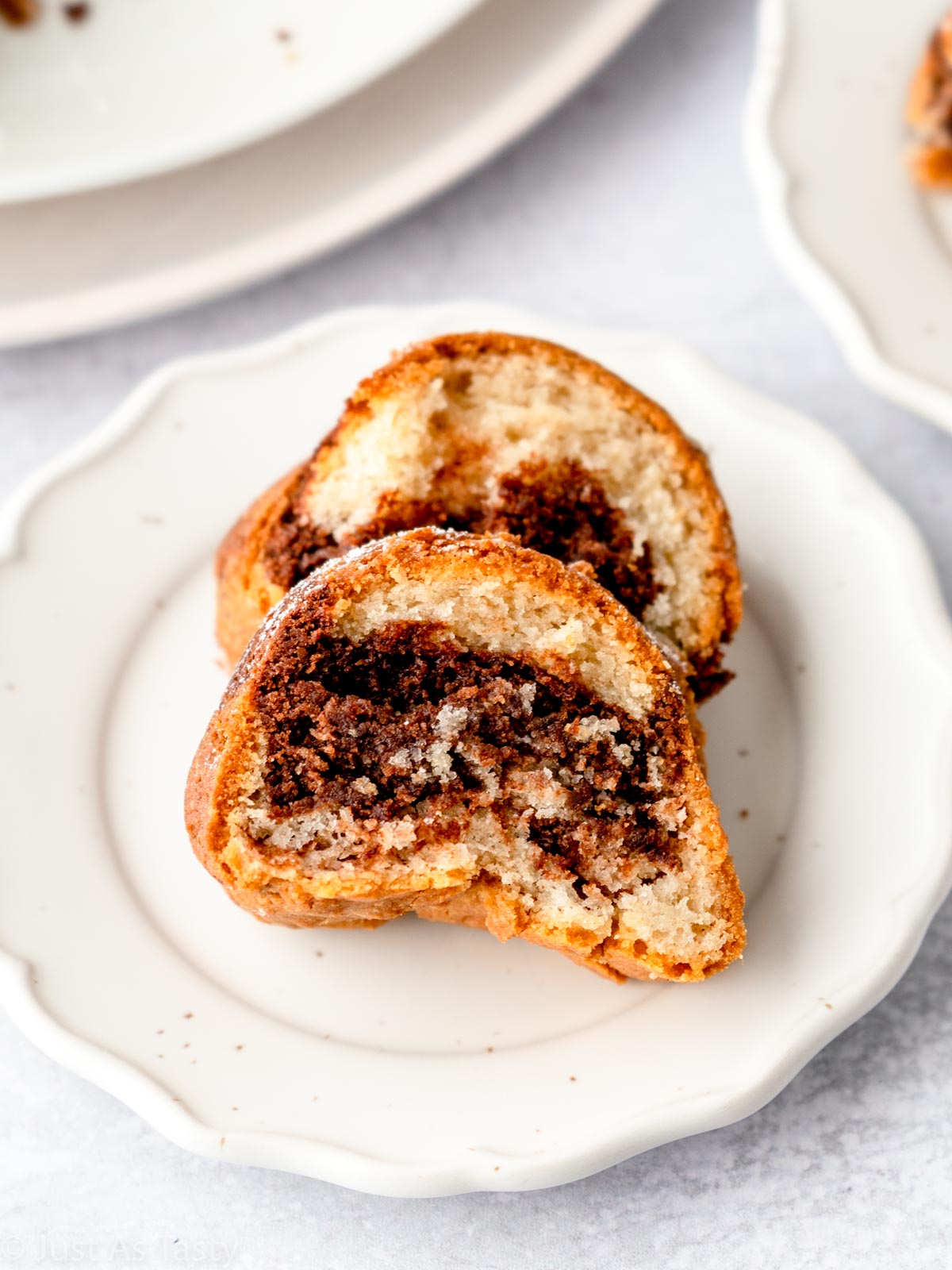 Two slices of eggless marble cake on a white plate. 