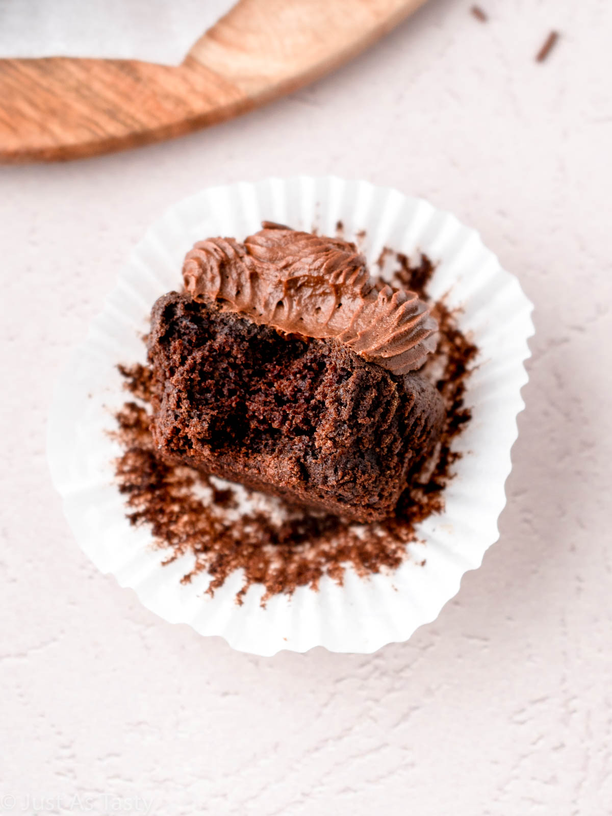 Frosted chocolate cupcake with bite taken out of it.