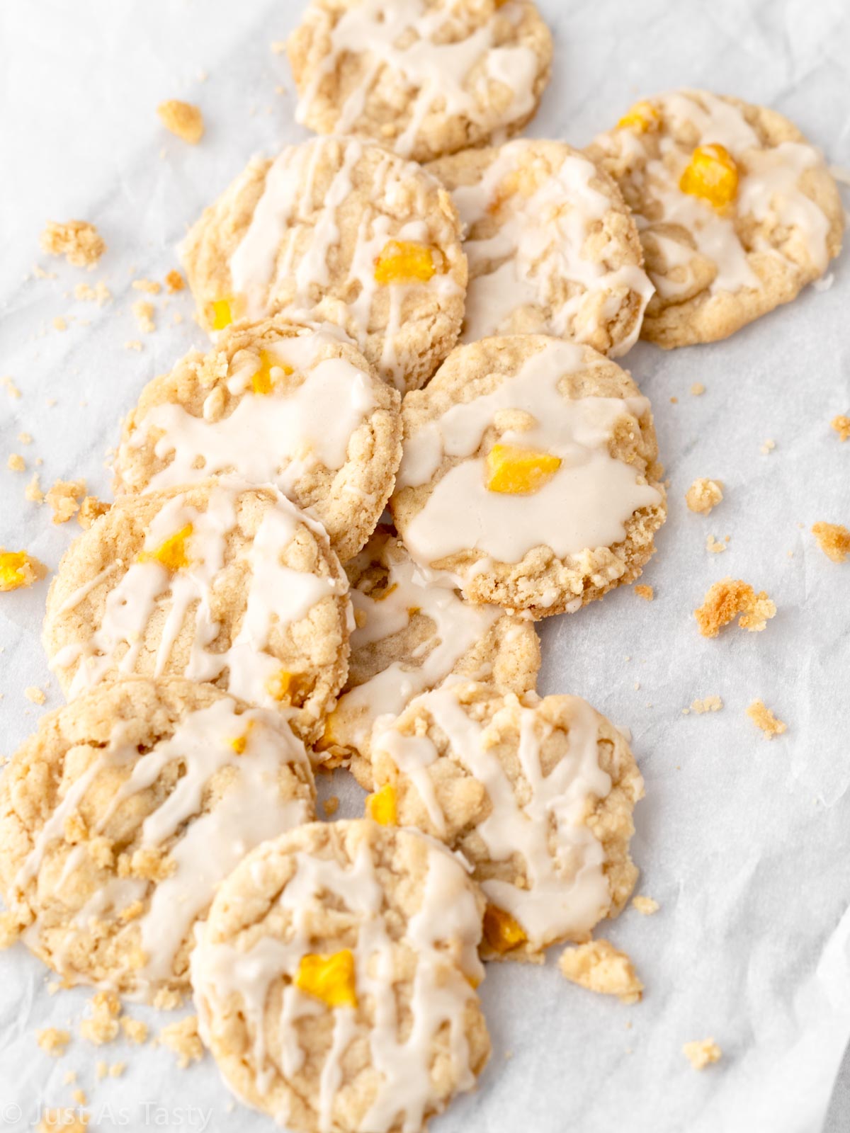 Glazed peach cobbler cookies on parchment paper.