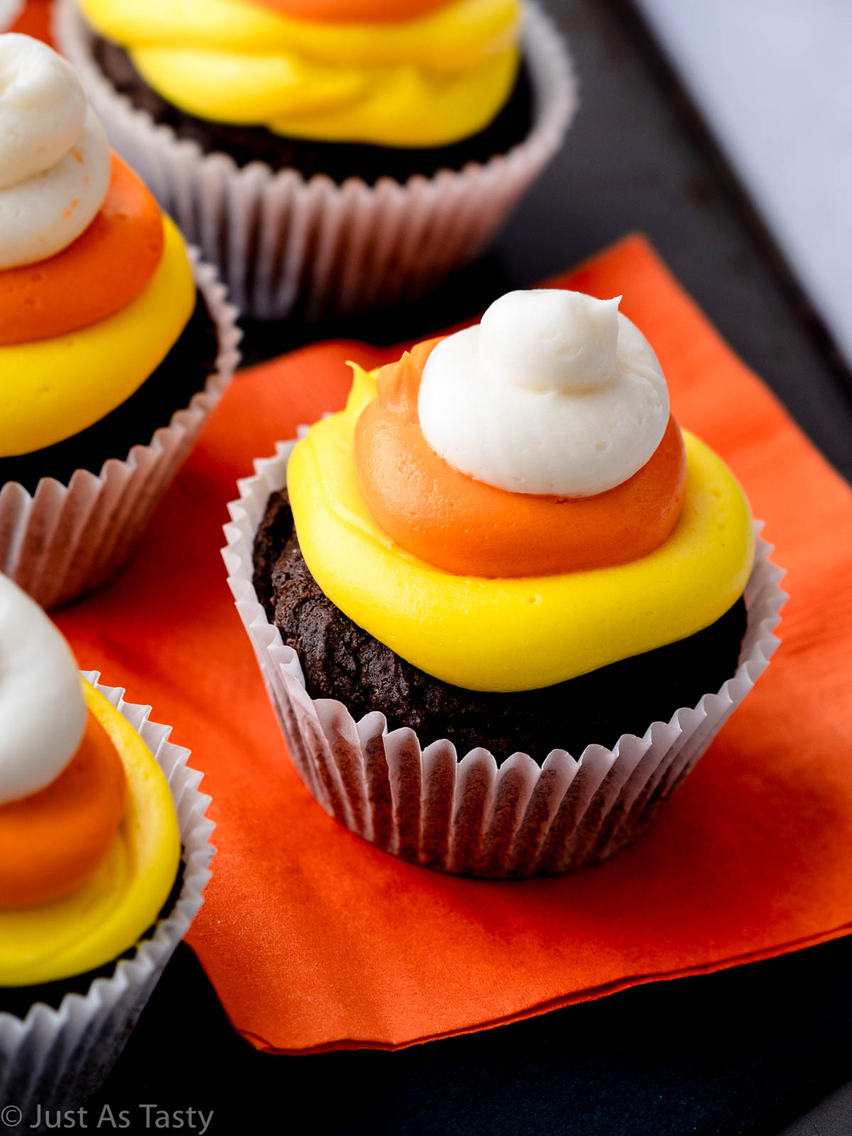 Close-up of a chocolate cupcake topped with candy corn frosting. 
