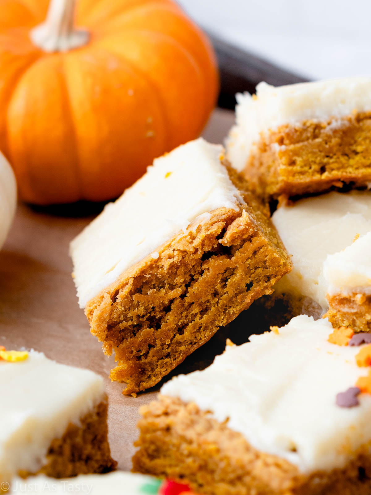 Close-up of a pumpkin bar topped with cream cheese frosting.