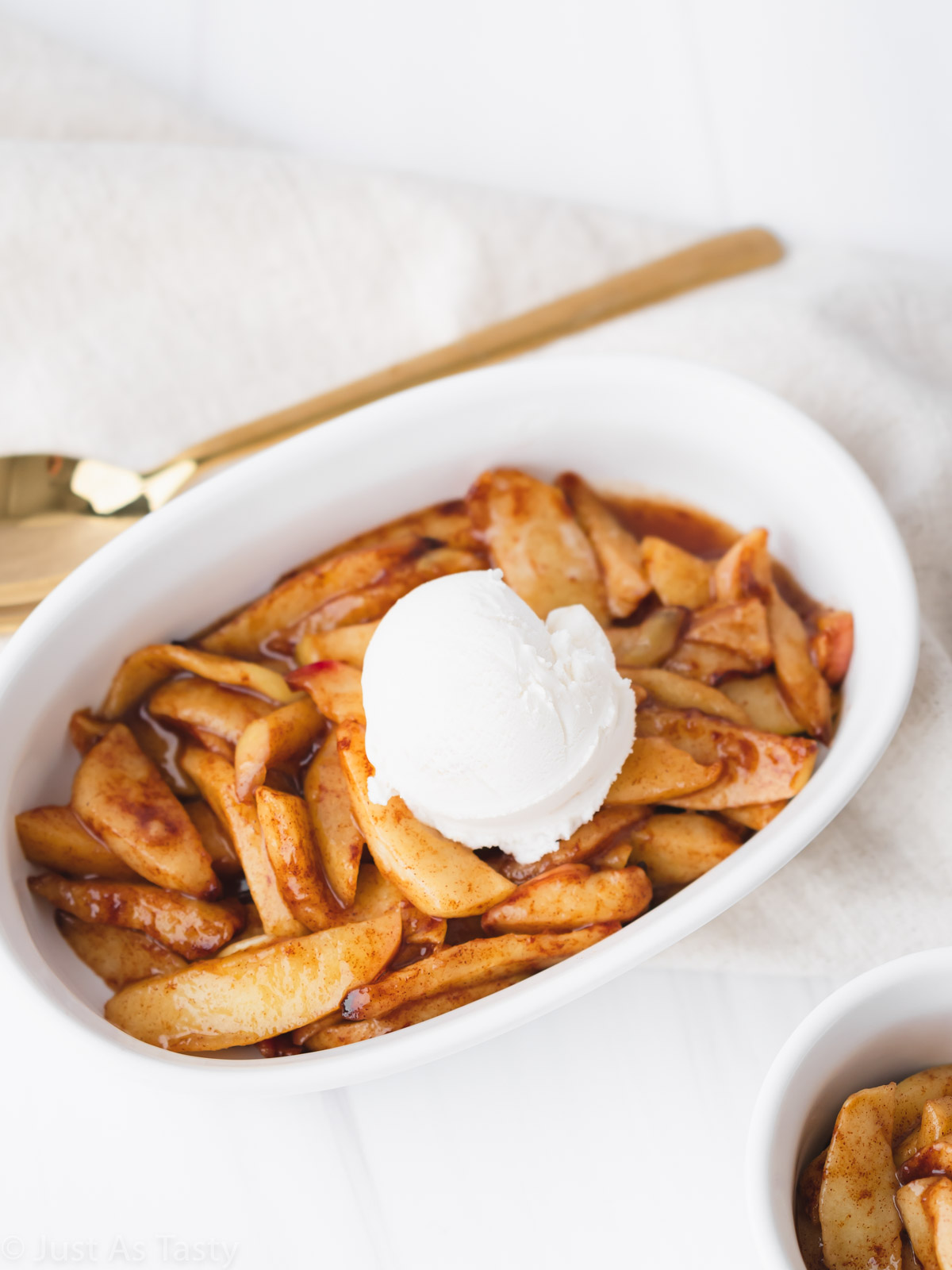 Air fryer apples topped with a scoop of vanilla ice cream. 