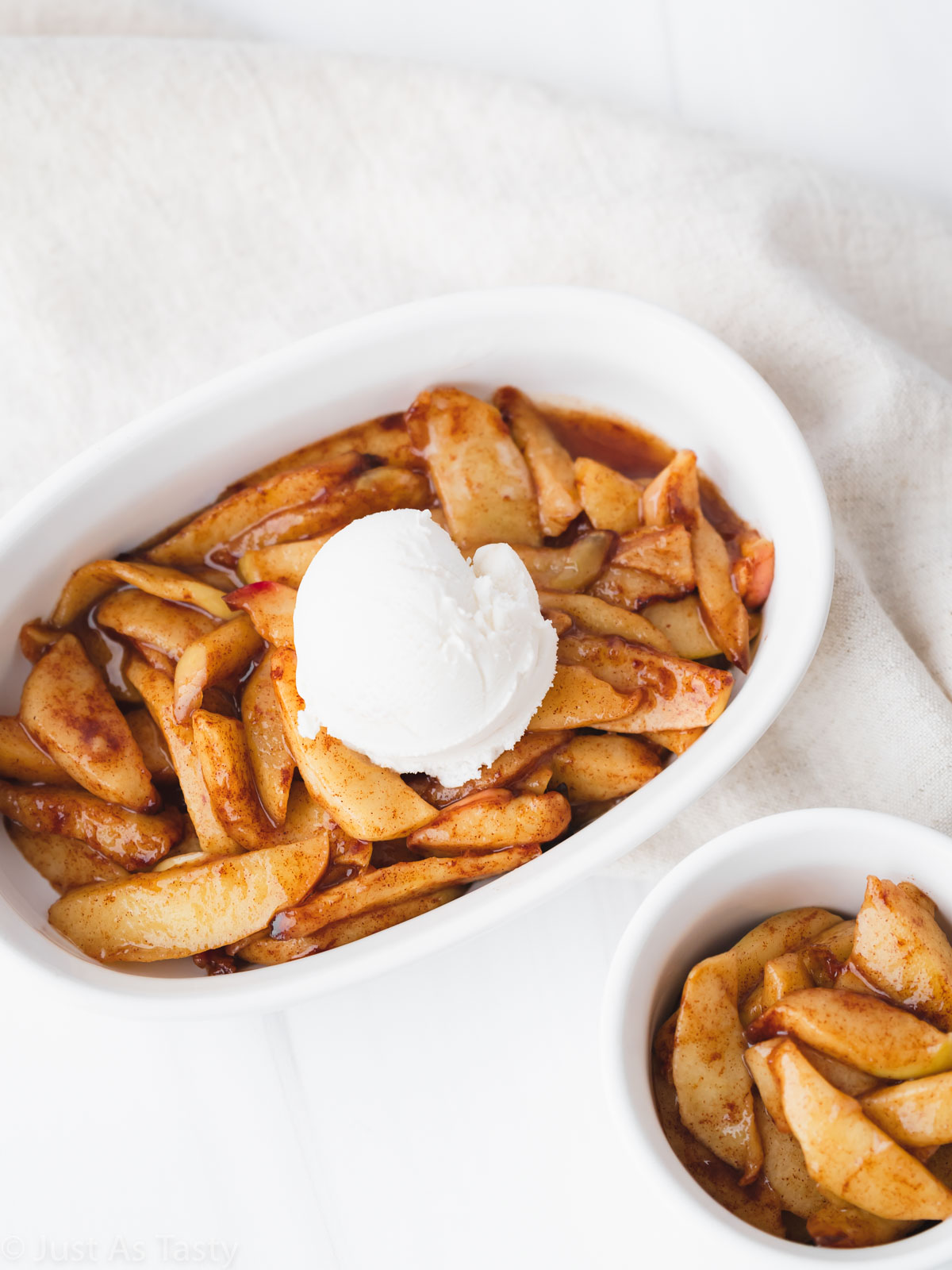 Bowl full of air fryer apples topped with a scoop of ice cream. 