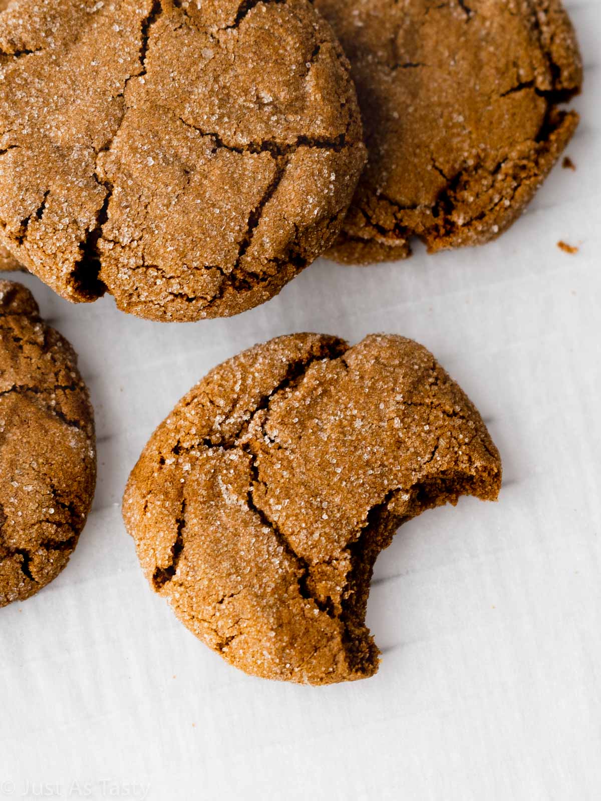 Close-up of a gingersnap cookie with a bite taken out. 