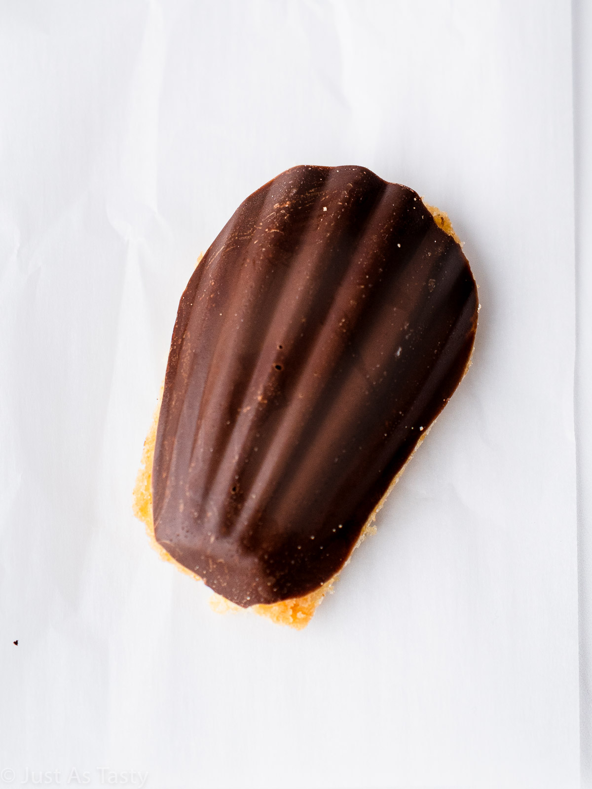 Close-up of a chocolate dipped madeleine cookie. 