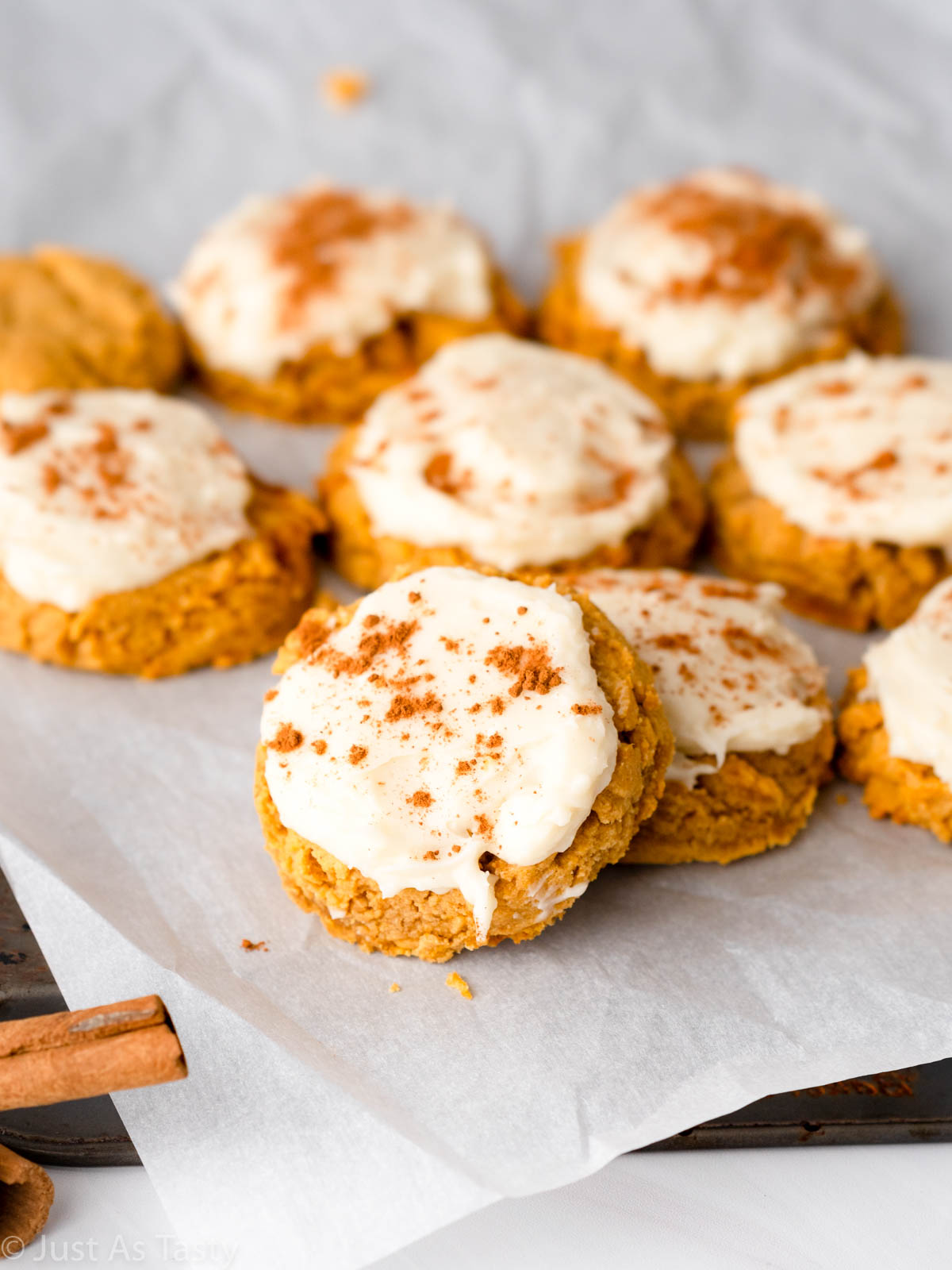 Frosted gluten free pumpkin cookies on a baking sheet. 