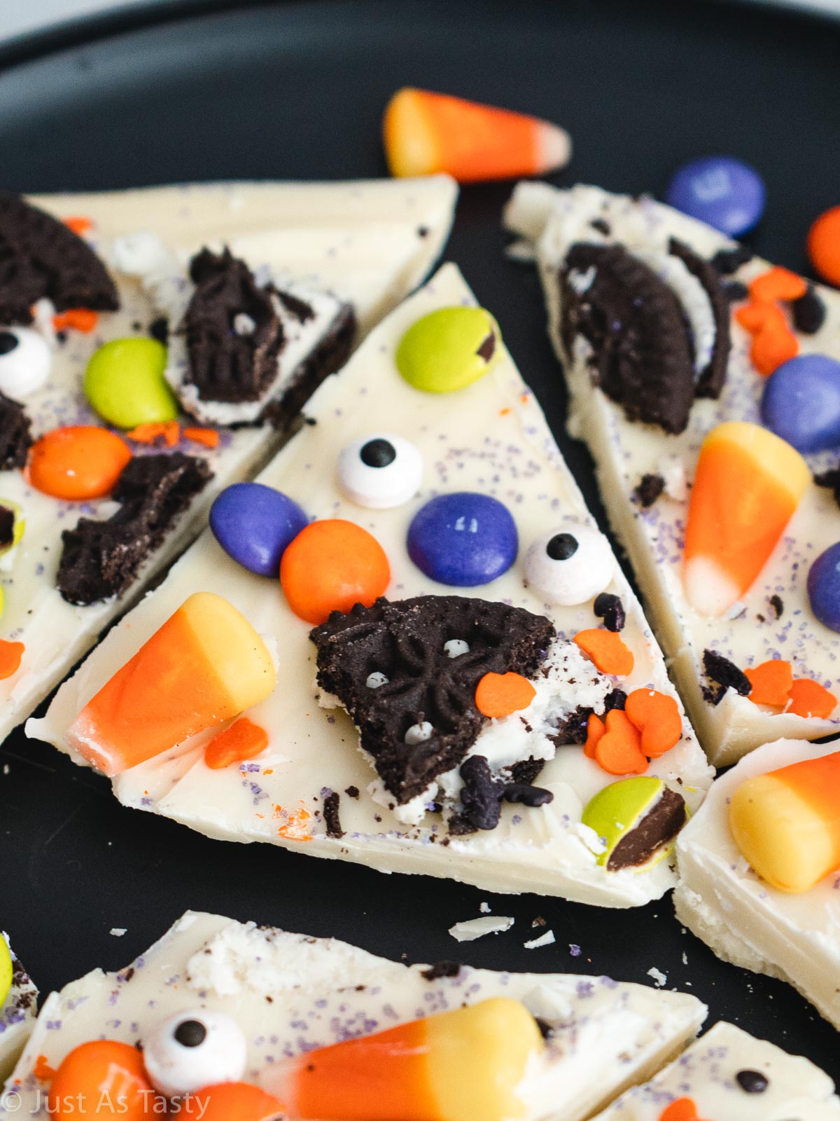 Close-up of a piece of white chocolate Halloween bark topped with various pieces of Halloween candy. 